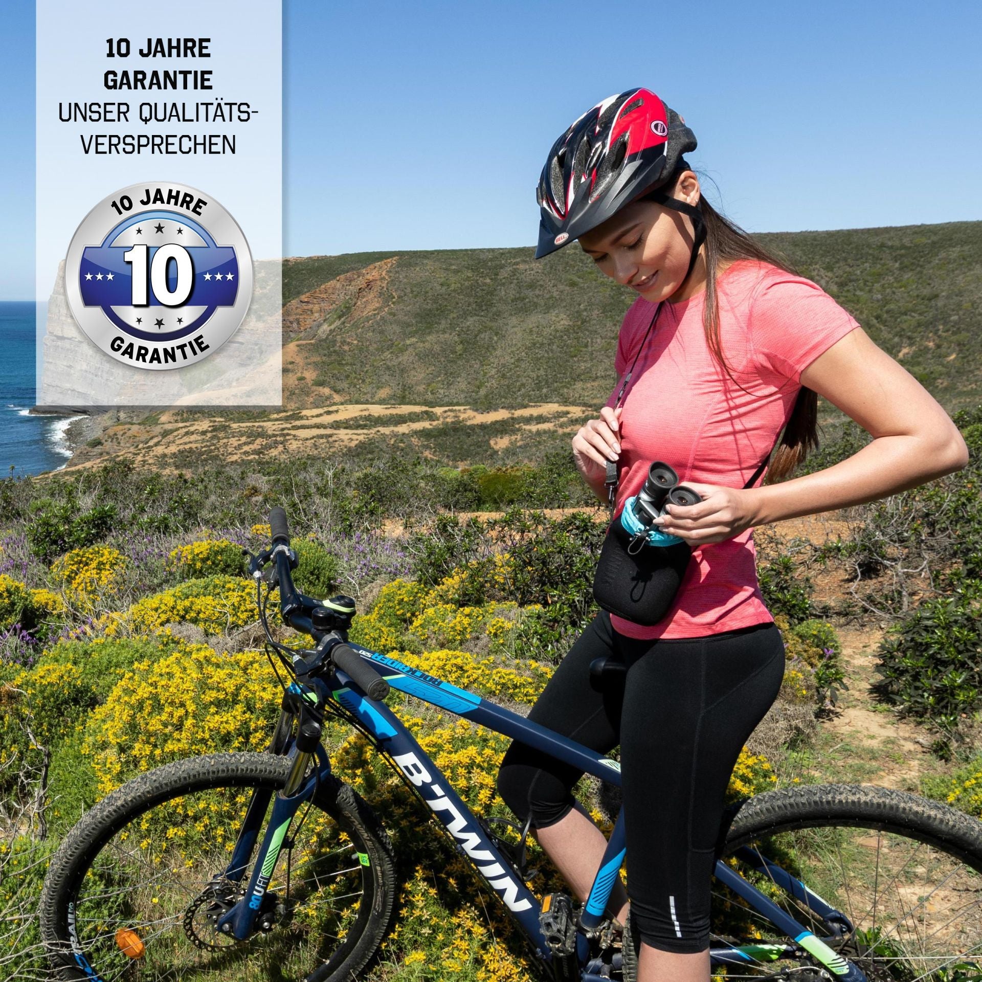 Steiner BluHorizons 10x26 – Frau mit Mountainbike am Klippenrand, hält Fernglas, 10 Jahre Garantie als Qualitätsversprechen