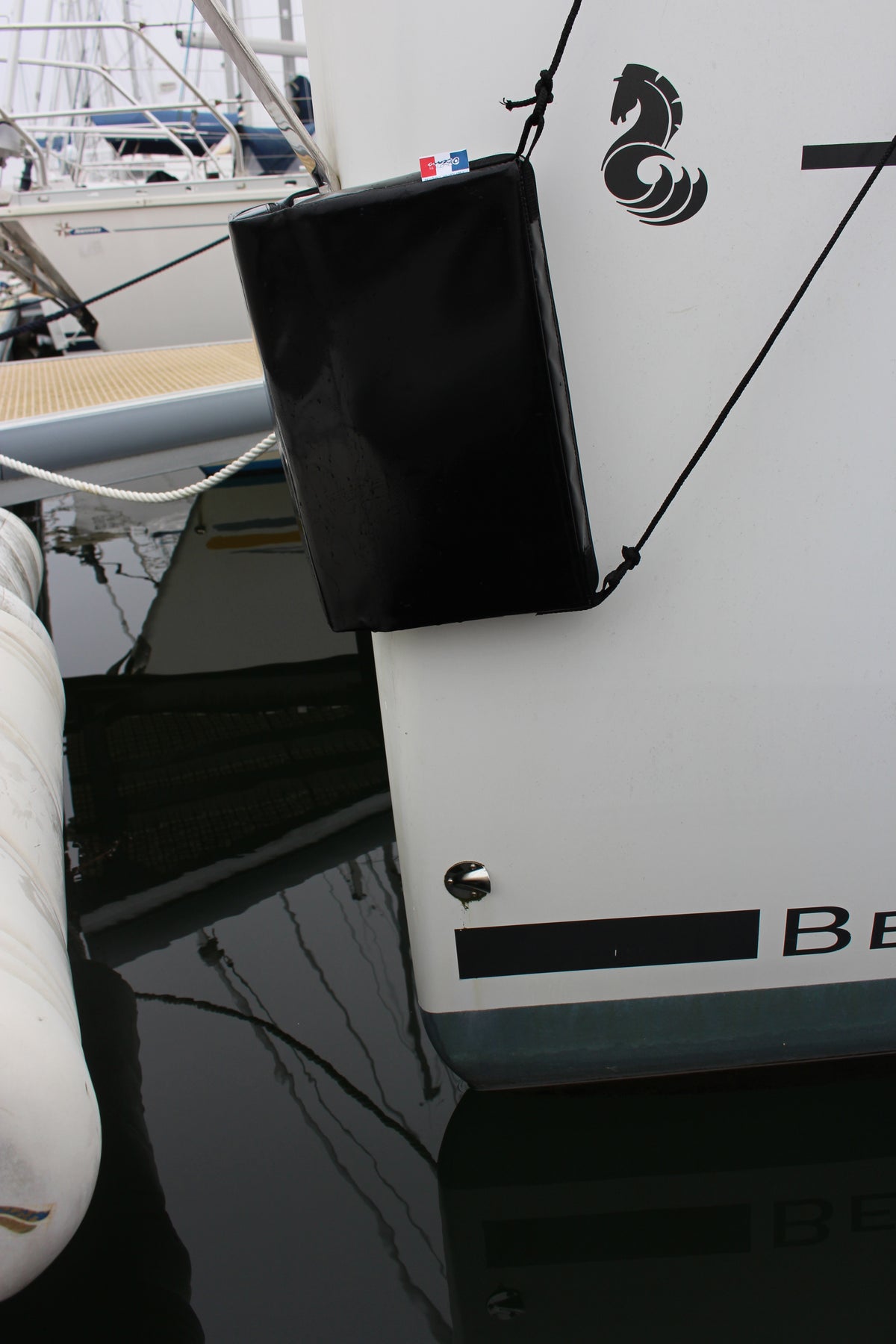 Outils Oceans Flacher Fender FT4020B – schwarzer Fender hängt am Segelboot-Rumpf im Hafen