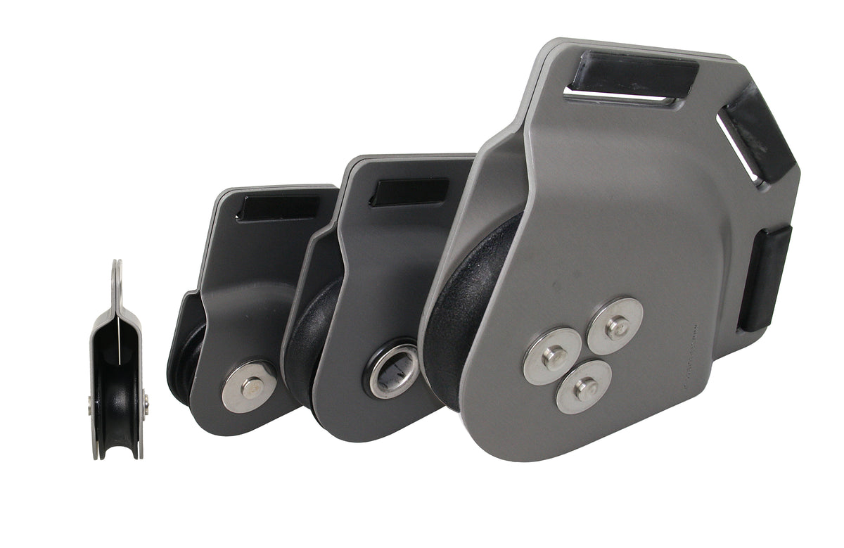 Vier SEA SURE Schothornblöcke SS0487, SS0488, SS0490 und SS0492 aus anthrazit eloxiertem Aluminium in unterschiedlichen Größen, mit dunklen Rollen und Gurtbandschlitzen, Seitenansicht und schräge Ansichten vor weißem Hintergrund.